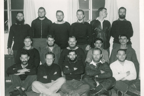 MARION 14 (April 1957-March 1958): Back (L-R) Cecil Neumann (Radio Technician), T.J. Roets (Meteorologist/Leader from September), B.C. Potgieter (Meteorologist), Dick J. Bonnema (Meteorologist), Petrus S. "Piet" du Toit (Meteorologist/Leader to August), Ray W. Vice (Ionosphericist to August); Middle: Willem A. van Huyssteen (Meteorologist), Johnny A. Stergianos (Medic), Ken Edmunds (Radio Operator), ? van der Merwe (PWD), ? (PWD); Front: S. "Vossie" Vorster (Cleaner/Labourer), ? (Aerial Rigger), ? (PWD), W. Thiel (Diesel Mechanic to August), W.F. Radley (Cook) Note: the three PWD personnel and the Rigger left the island in August; W. Thiel was replaced by Jan Hoogstad and W.F. Radley by P./R. "Mac" MacLean in November.