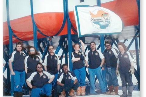 SANAE 41 (2002): Back (L-R) Leon du Plessis (Potch Kassie/Deputy Leader), Anton Grobler (Radio Technician), Steven Jansen (Diesel Mechanic), Meraai Smit (Doctor), Nole Green (Diesel Mechanic), Willem Truter (Mechanical Engineer), Garron Fish (Radar Engineer); Front: Kobus Steyn (Meteorologist/Team Leader), Joshua Nkosi (Electrical Engineer).